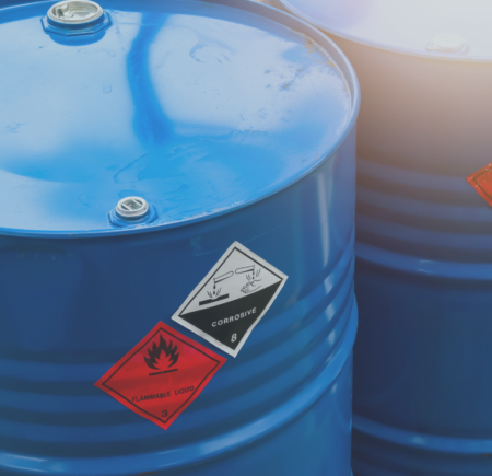 Two bright blue chemical drums with flamable warning stickers